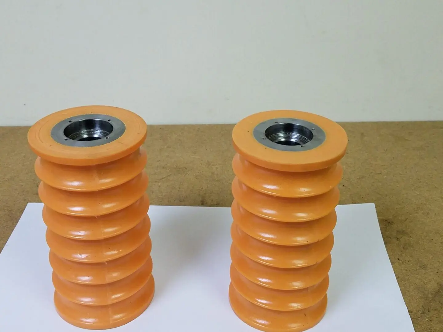 A couple of orange wheels sitting on top of a table.